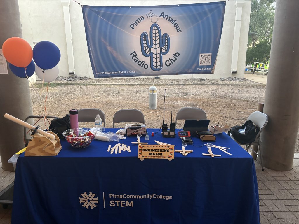 Pima Amateur Radio Club student event table with radios, engineering activities, and club banner
